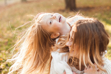 Happy daughter with mother is having fun walking in the park.