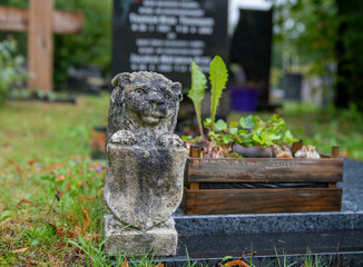 Löwe mit Schild auf Grabumrandung