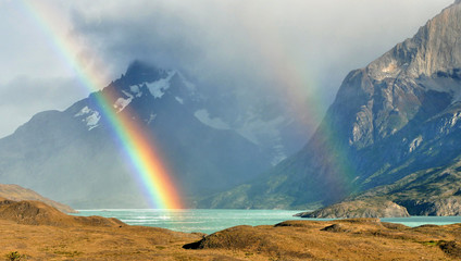 Rainbow over lake in mountains. Argentina.