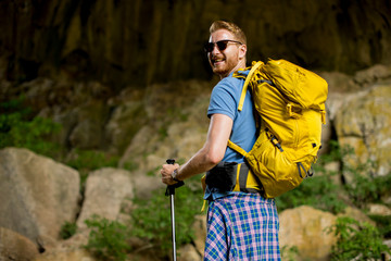 Caucasian male hiker with backpack hiking on sunny day