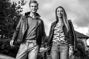 Young beautiful couple in garden near house. Black-white photo.
