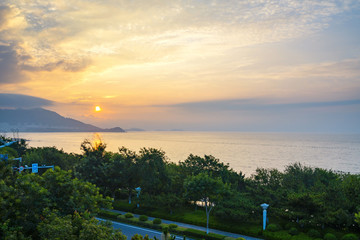 Luxuriant trees and sunrise at the seaside, Qingdao, China