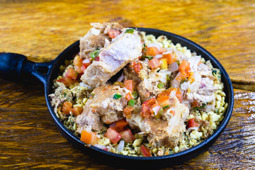 Pork ribs with crumbs, chopped vegetables and onion. Brazillian tipical food.