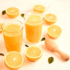 freshly squeezed orange juice in glasses on the kitchen table with slices of oranges, concept of diet and healthy lifestyle