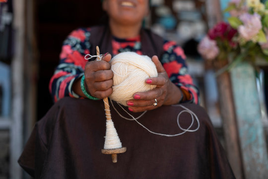 A Sherpa woman from Gosainkund spins baby Yak wool using the traditional method with a spindle, Langtang region, Nepal