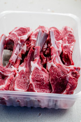 Raw Bloody Lamb Chops Meat in Plastic Package / Box or Container.