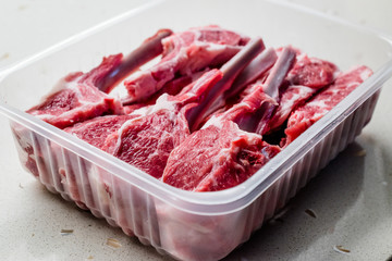 Raw Bloody Lamb Chops Meat in Plastic Package / Box or Container.