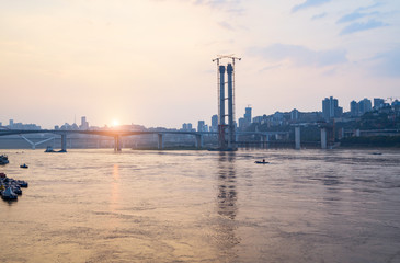 At sunset, the Yangtze River Bridge under construction in Chongqing, China