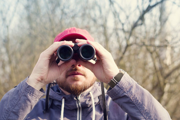 Man with the field-glass watches birds. Ornithology. Birdwatching