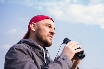 Man with the field-glass watches birds. Ornithology. Birdwatching