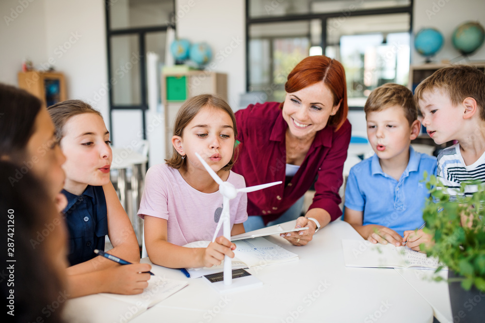 Canvas Prints a group of small school kids with teacher in class learning about environment.