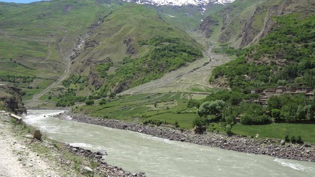 Kulob to Qalai Khumb Pamir Highway along the Panj River with View of a Village on the Afghanistan Side on a Sunny Blue Sky Day