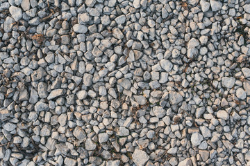 A lot of small pebbles lies on a path in the park. Preparing the road for leveling. Stone background
