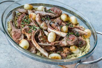 Lamb Chops with Shallots, Green Pea Hummus and Fresh Thyme Leaves served in Big Glass Tray Plate.