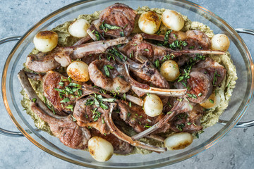 Lamb Chops with Shallots, Green Pea Hummus and Fresh Thyme Leaves served in Big Glass Tray Plate.