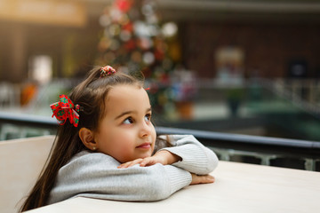 little girl sitting in a cafe at christmas