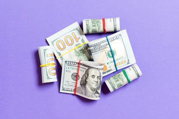 Stacks of one hundred dollars banknotes close-up on colored background business concept top view with copy space