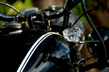 Fototapeta na wymiar Close up of crystal diamond shaped doorknob used as shifter on old black vintage motorcycle.