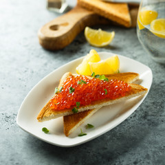 Red caviar on toast served with lemon