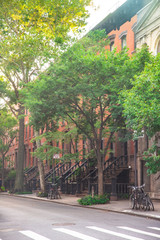 Summer Street scene from New York City with brownstones apartments homes and trees. 