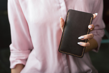 Obraz premium a leather case for the phone in the girl s hand