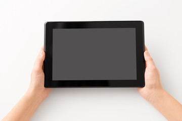 gadget and technology concept - close up of hands with black tablet computer smartphone