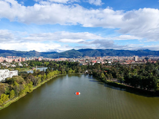 Fototapeta premium Areal view of bogota whit a blue sky with clouds, residential area with a lake, you can see the city and the mountain 