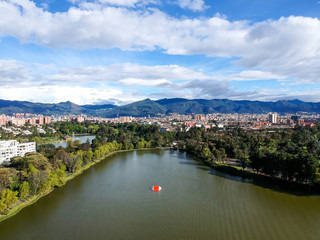 Areal view of bogota whit a blue sky with clouds, residential area with a lake, you can see the city and the mountain 