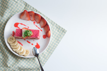 layered strawberry cake with slice of banana and strawberry