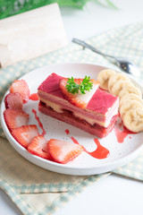 layered strawberry cake with slice of banana and strawberry