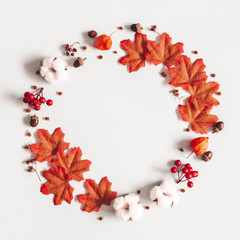 Autumn composition. Wreath made of flowers, maple leaves on gray background. Autumn, fall, thanksgiving day concept. Flat lay, top view, copy space