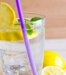 Glasss of mojito with lemon and drinking straw