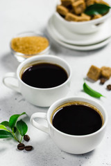 Two cups of black coffee with  brown sugar. Selective focus, space for text.