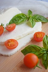 Home-made sliced Adyghe cheese lying on wooden board.