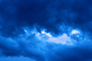 Obraz premium Blue hour sky clouds background. Beautiful landscape with stormy clouds and purple sun on sky