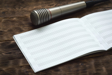Music book with a copy space and microphone on a table.