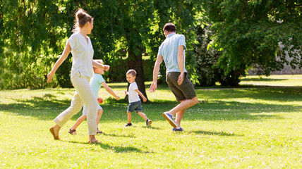 family, leisure and people concept - happy mother, father and two little sons having fun and playing at summer park