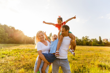Fototapeta premium young familiy running through a yellow field