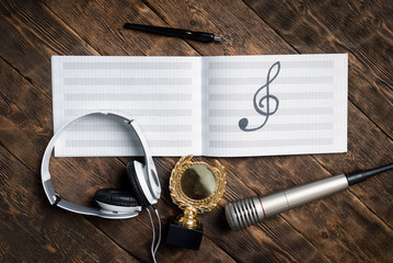 Music award concept background. Musical book with a treble clef, golden medal award trophy,...