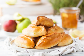 Traditional Russian pastries filled with apples on a white plate