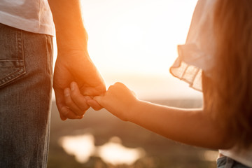 Happy father and daughter holding hands together - obrazy, fototapety, plakaty