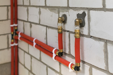 Plumbing pipes for water supply on a white brick wall during construction and repair