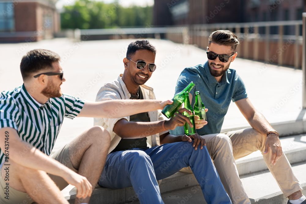 Wall mural leisure, male friendship and people concept - happy men or friends toasting and drinking beer on street in summer