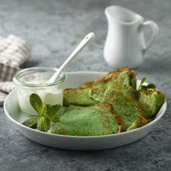 Homemade spinach pancakes with sour cream