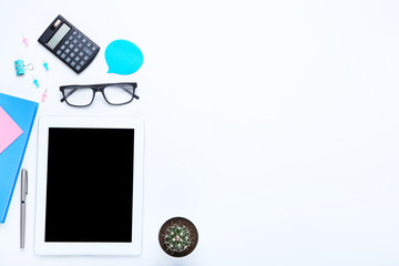 Tablet computer with office supplies on white background