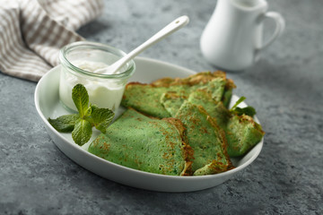 Homemade spinach pancakes with sour cream