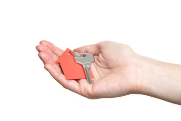 Female hand holding silver key with paper house on white background