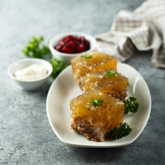 Festive meat jelly with sauces on white plate