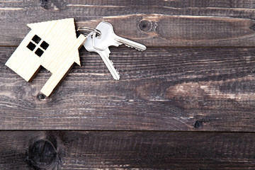 Silver keys with house symbol on brown wooden table