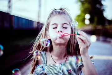 happy girl cute baby blowing soap bubbles